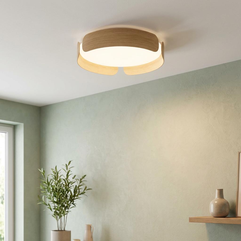 Modern round ceiling flush light with an oak wood effect frame glowing in a sage green room.