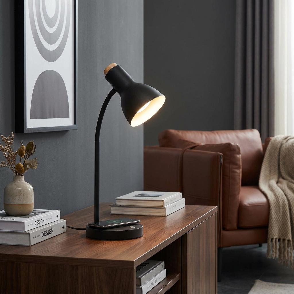 Modern black desk lamp with wireless charging base illuminates a wooden sideboard in a contemporary living room.