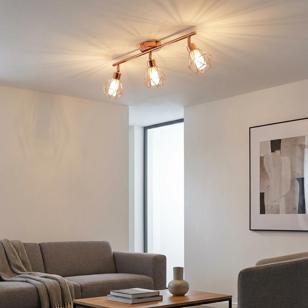 Copper 3-light bar spotlight with geometric wire cages mounted on the ceiling of a modern living room.