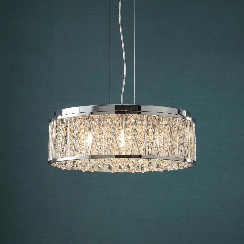 Circular chrome pendant light featuring crystal drops and a criss-cross wire design against a teal wall.