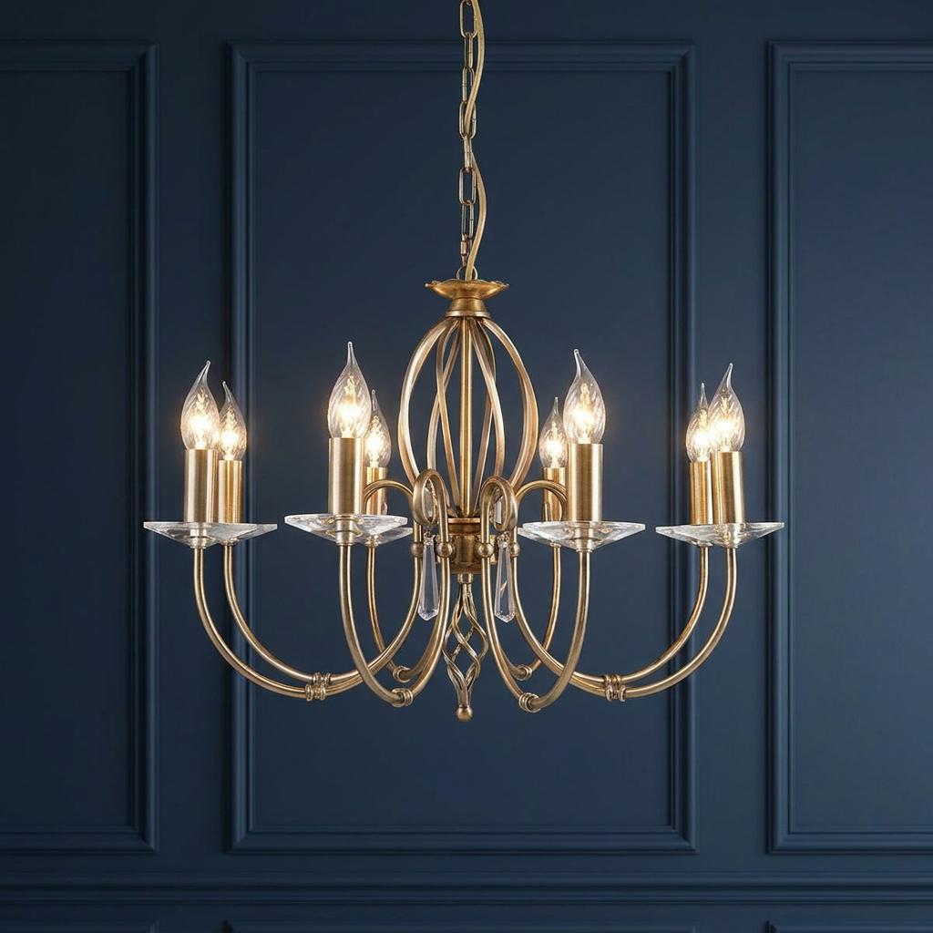 Eight-light aged brass chandelier with candle-style bulbs and glass accents against a dark blue paneled wall.
