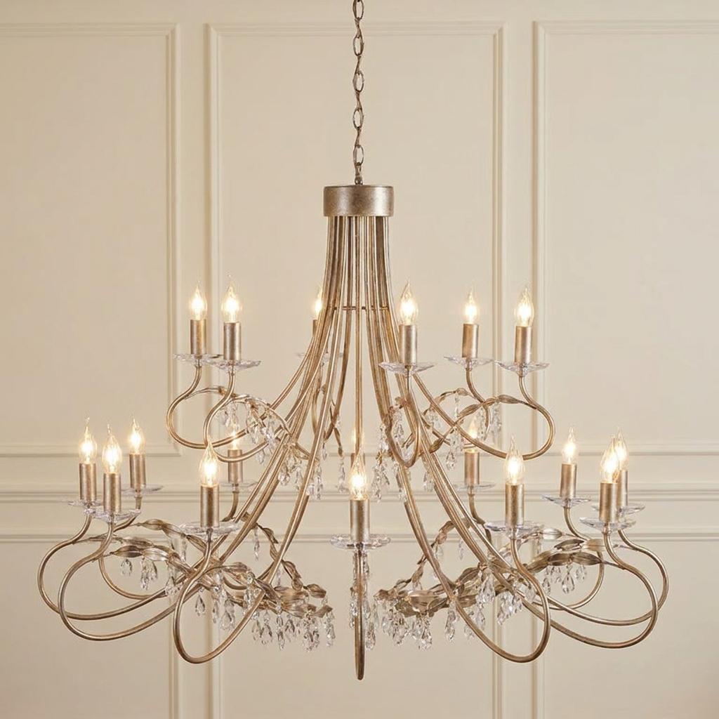 Elstead Christina 18 light chandelier with a silver and gold leaf finish and crystal drops against a paneled wall.