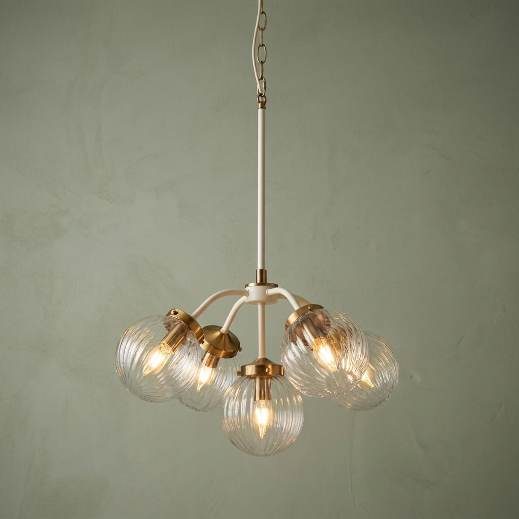 Elstead Cosmos 5-light ceiling pendant with brass accents and ribbed glass globes against a green wall.