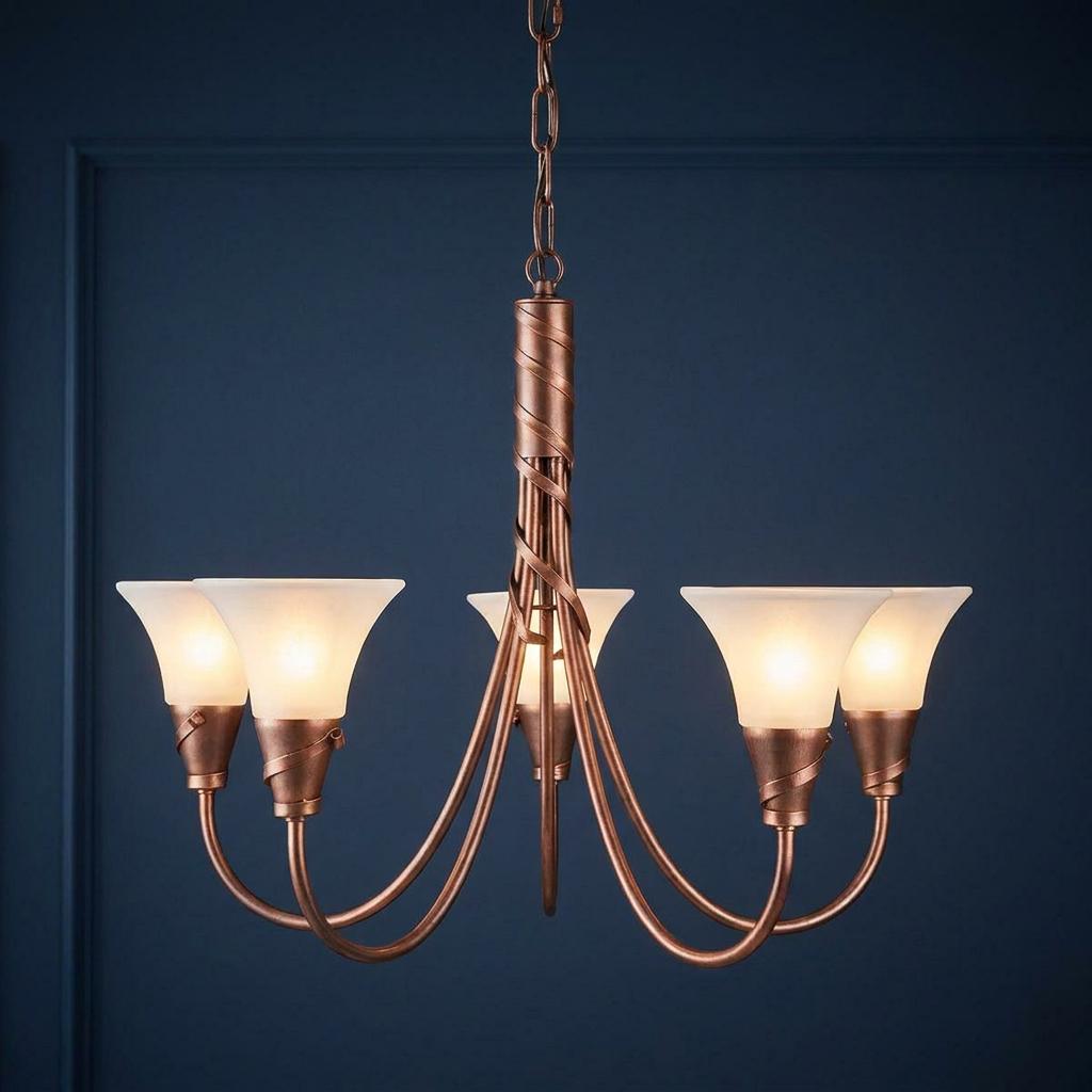 A 5-light copper chandelier with frosted glass shades against a dark blue paneled wall.