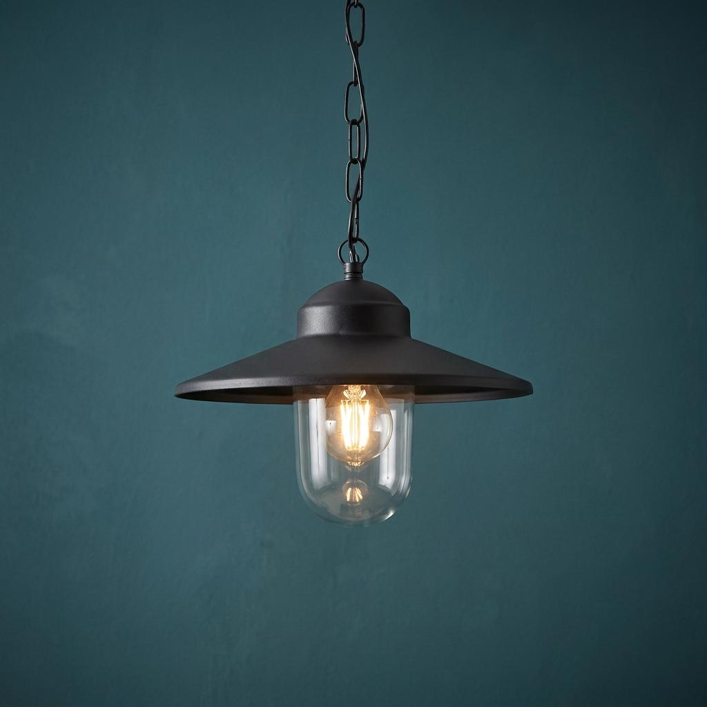 Elstead Karlstad black outdoor pendant light with a clear glass shade and lit bulb against a dark teal wall.