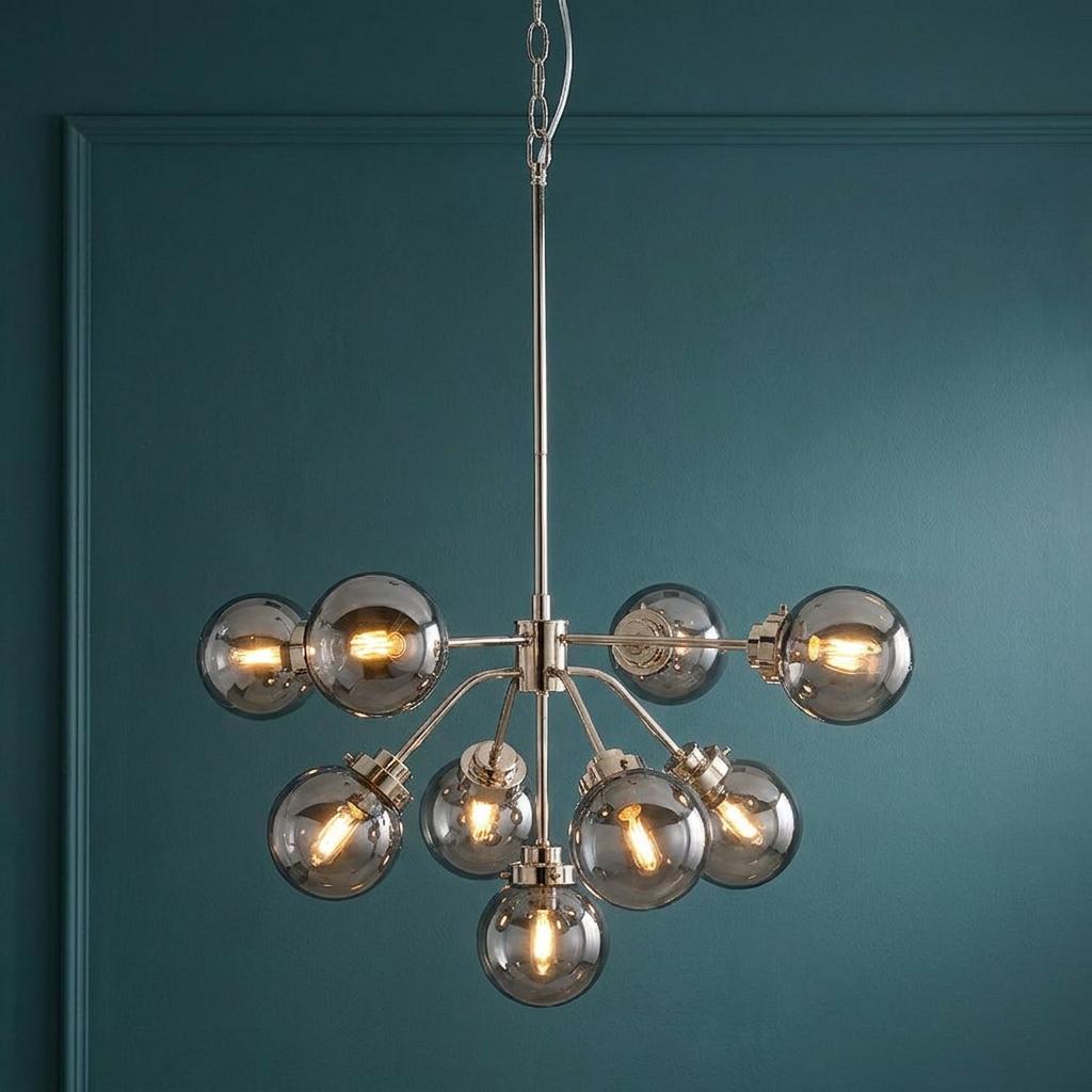 Modern 9-light chandelier with polished nickel finish and smoke glass globes against a dark teal wall.