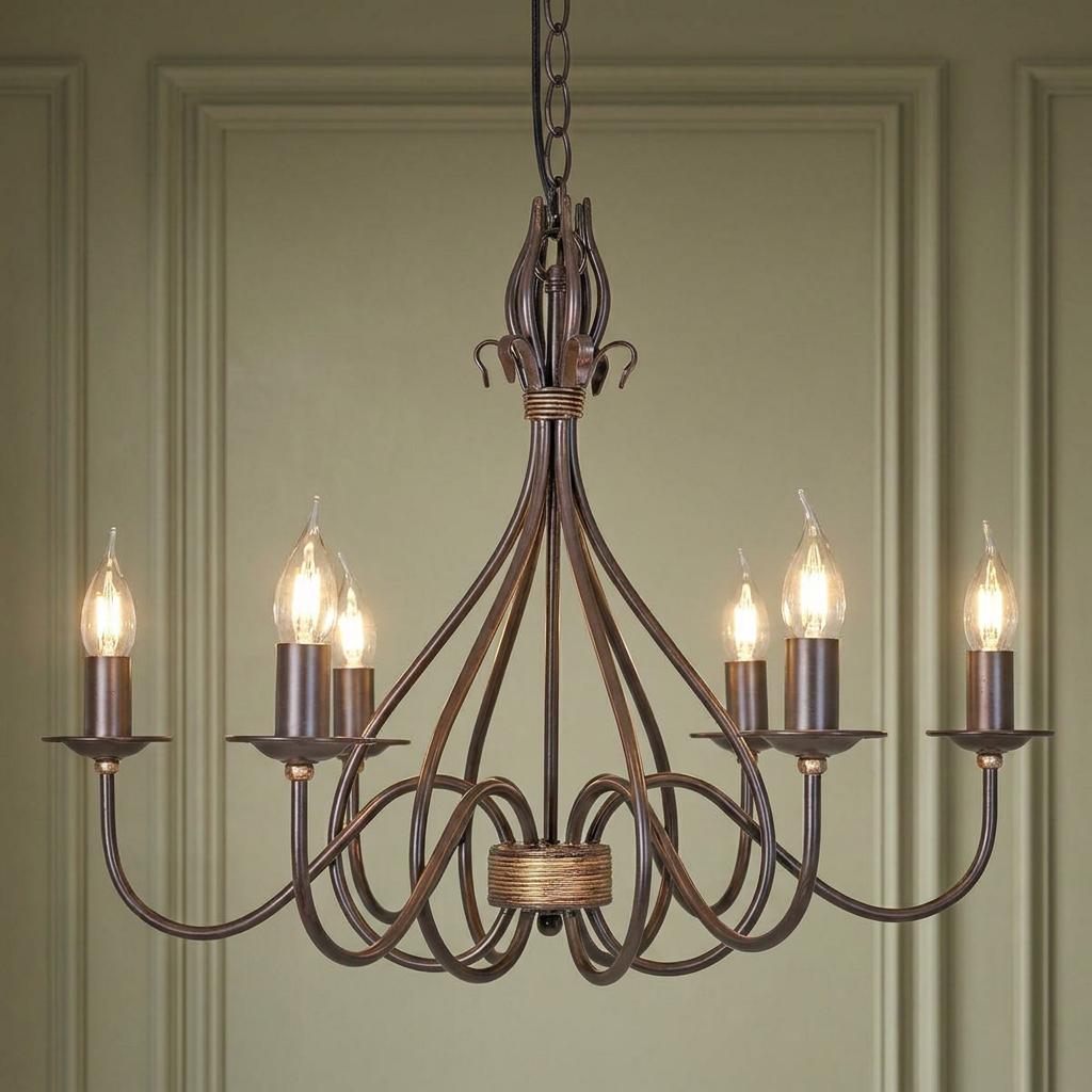 Traditional rust and gold 6-light chandelier with curved metal arms and candle bulbs against a green paneled wall.