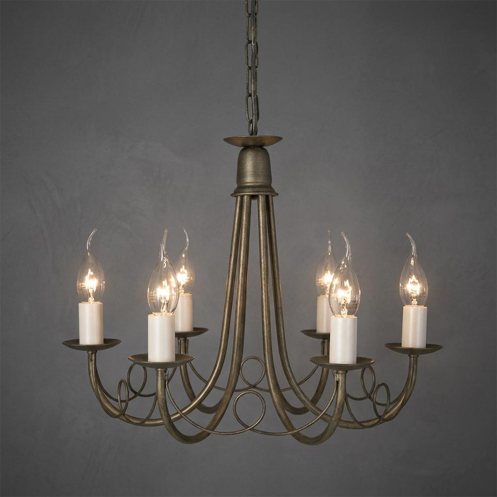 Traditional six-arm black and gold chandelier with elegant scroll details and glowing candle-style bulbs.