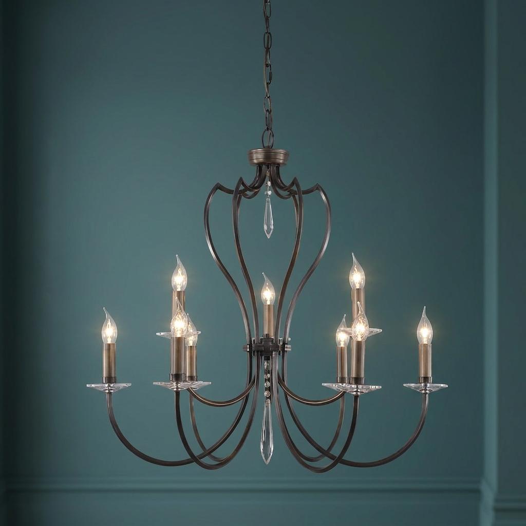 Elstead Pimlico 9-light dark bronze chandelier with candle bulbs and crystal drops against a teal wall.