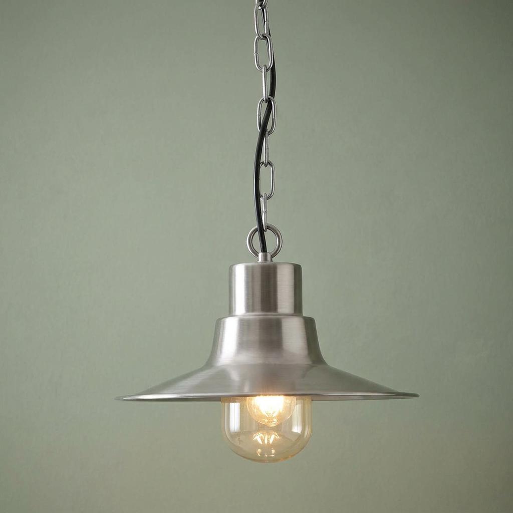 Antique nickel outdoor pendant light with a tiered metal shade and clear glass globe against a green background.