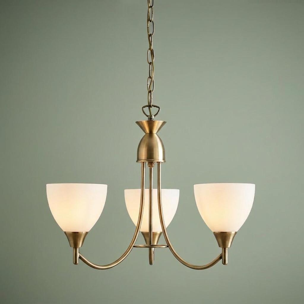 Endon Alton 3-arm antique brass pendant ceiling light with frosted glass shades against a sage wall.
