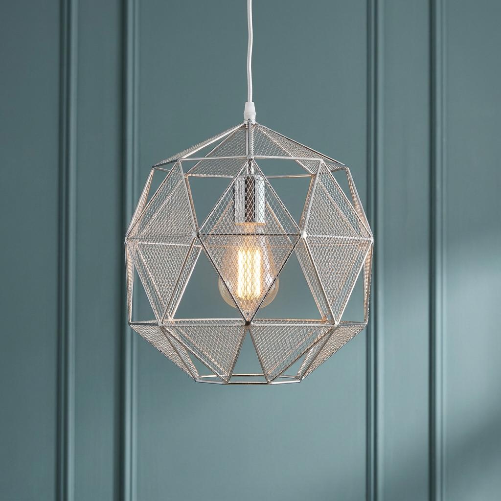 Geometric chrome mesh pendant light with a warm bulb, hanging against a teal paneled wall.