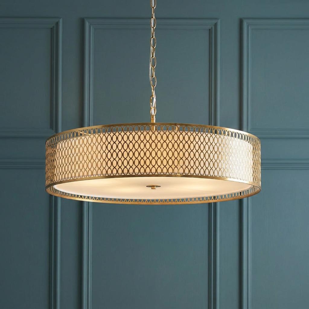 A gold mesh drum pendant light with a white diffuser hangs against a dark teal paneled wall.