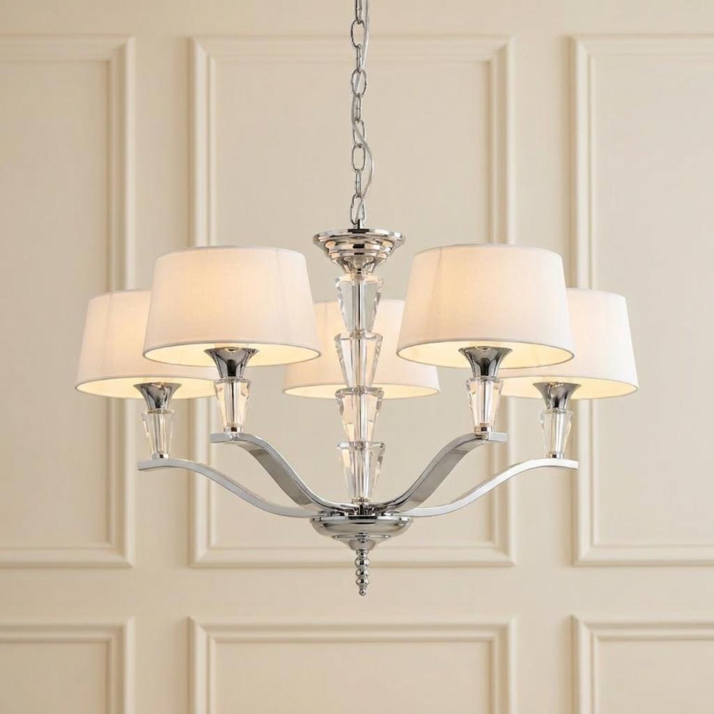 Endon Fiennes five-light chrome chandelier with crystal details and white fabric shades against a paneled wall.