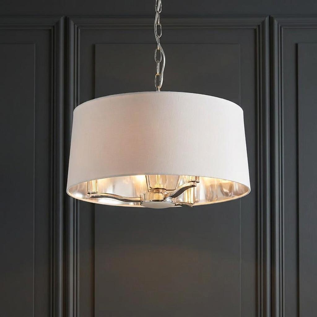 Endon Harvey 3-light pendant with a white drum shade and nickel chain against a dark grey panelled wall.