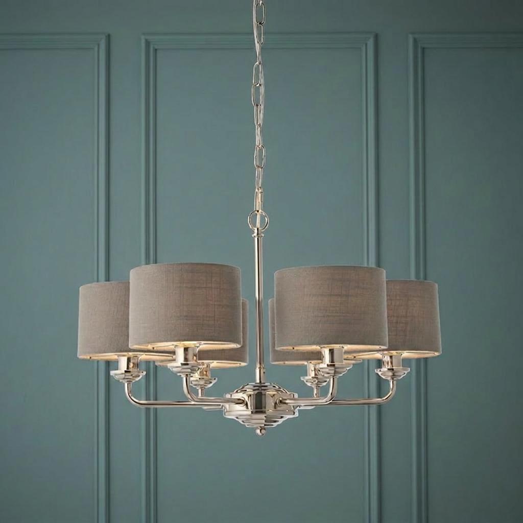 Bright nickel six-arm pendant light with charcoal grey fabric shades against a dark teal paneled wall.