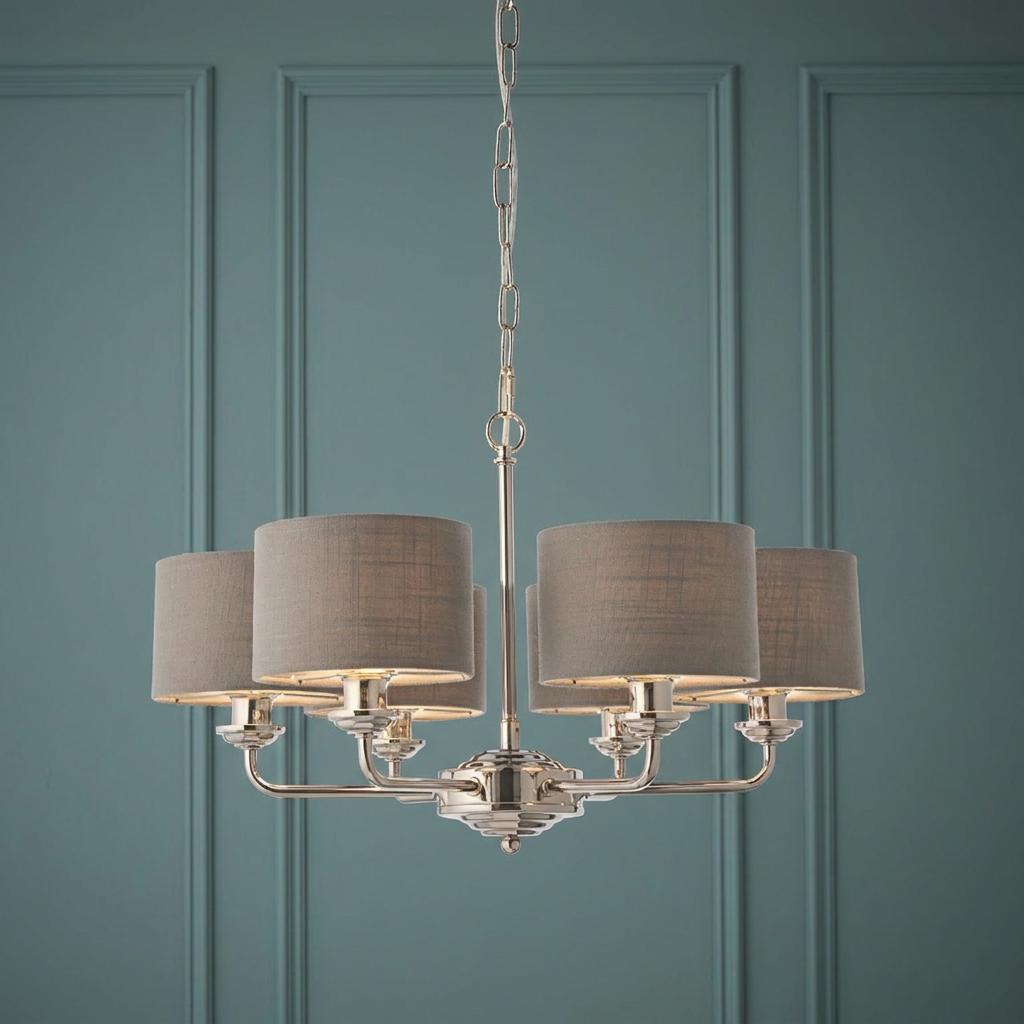 Bright nickel 6-arm pendant light with charcoal linen shades hanging against a teal paneled wall.
