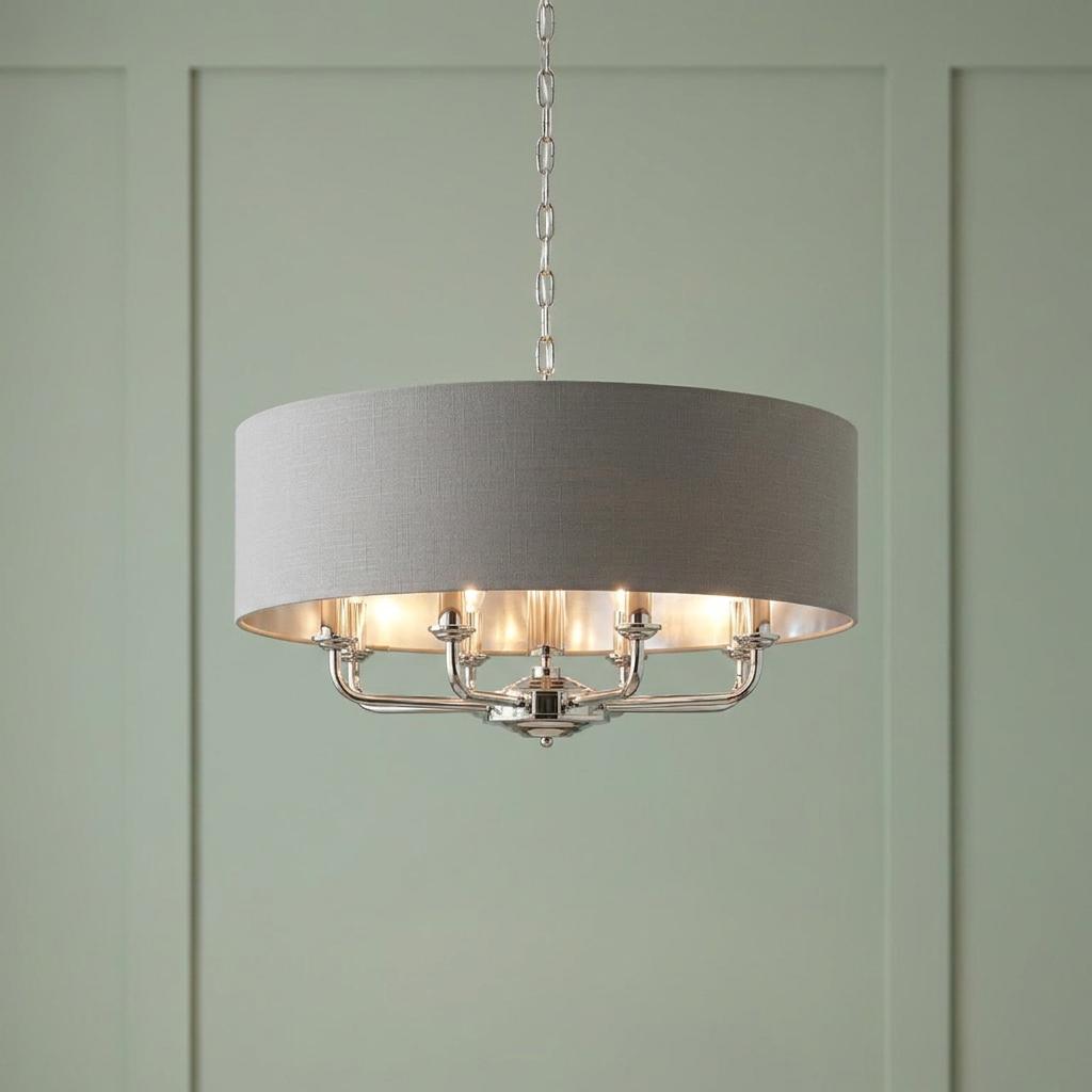Bright nickel 8-light pendant with a charcoal drum shade hanging against a sage green paneled wall.