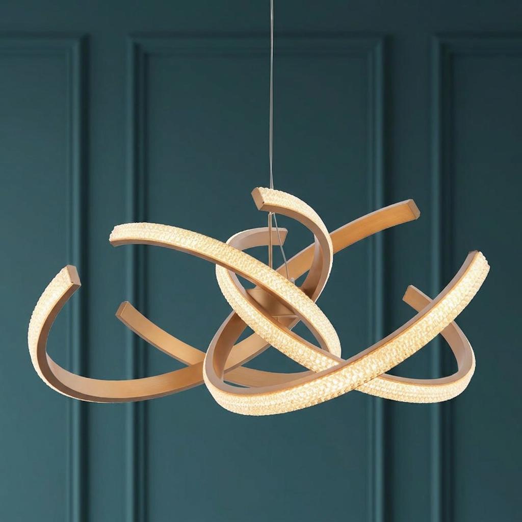 Modern gold pendant ceiling light with intertwining illuminated curved arms against a teal paneled wall.