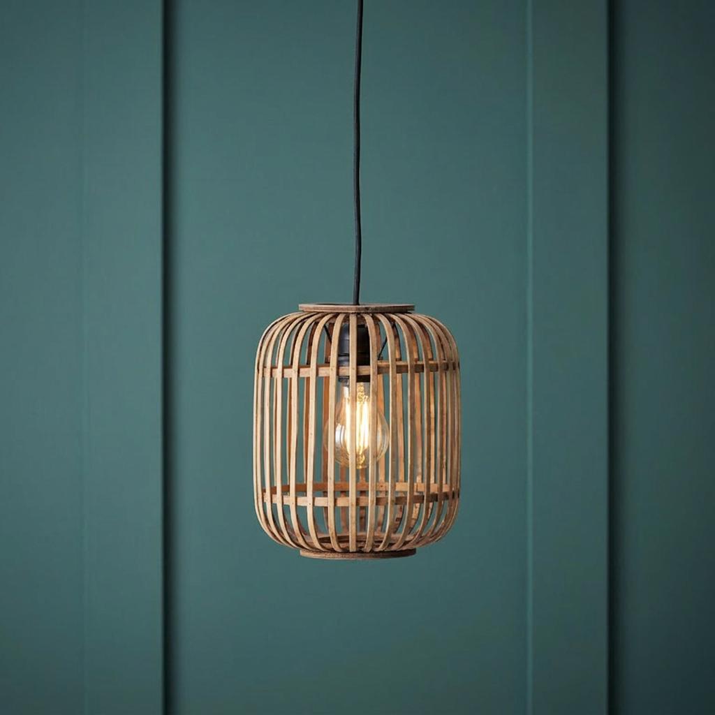 A lit bamboo cage pendant light hanging against a dark green paneled wall.