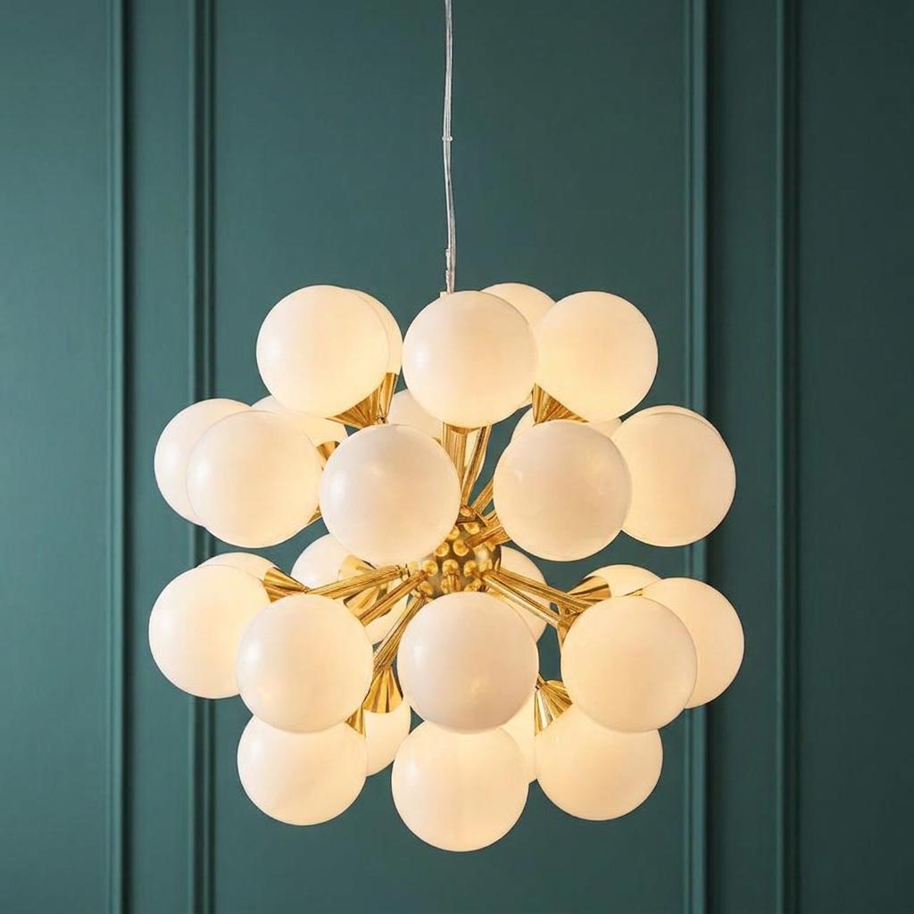 Endon Oscar 28 brass pendant ceiling light with frosted white glass globes against a teal paneled wall.