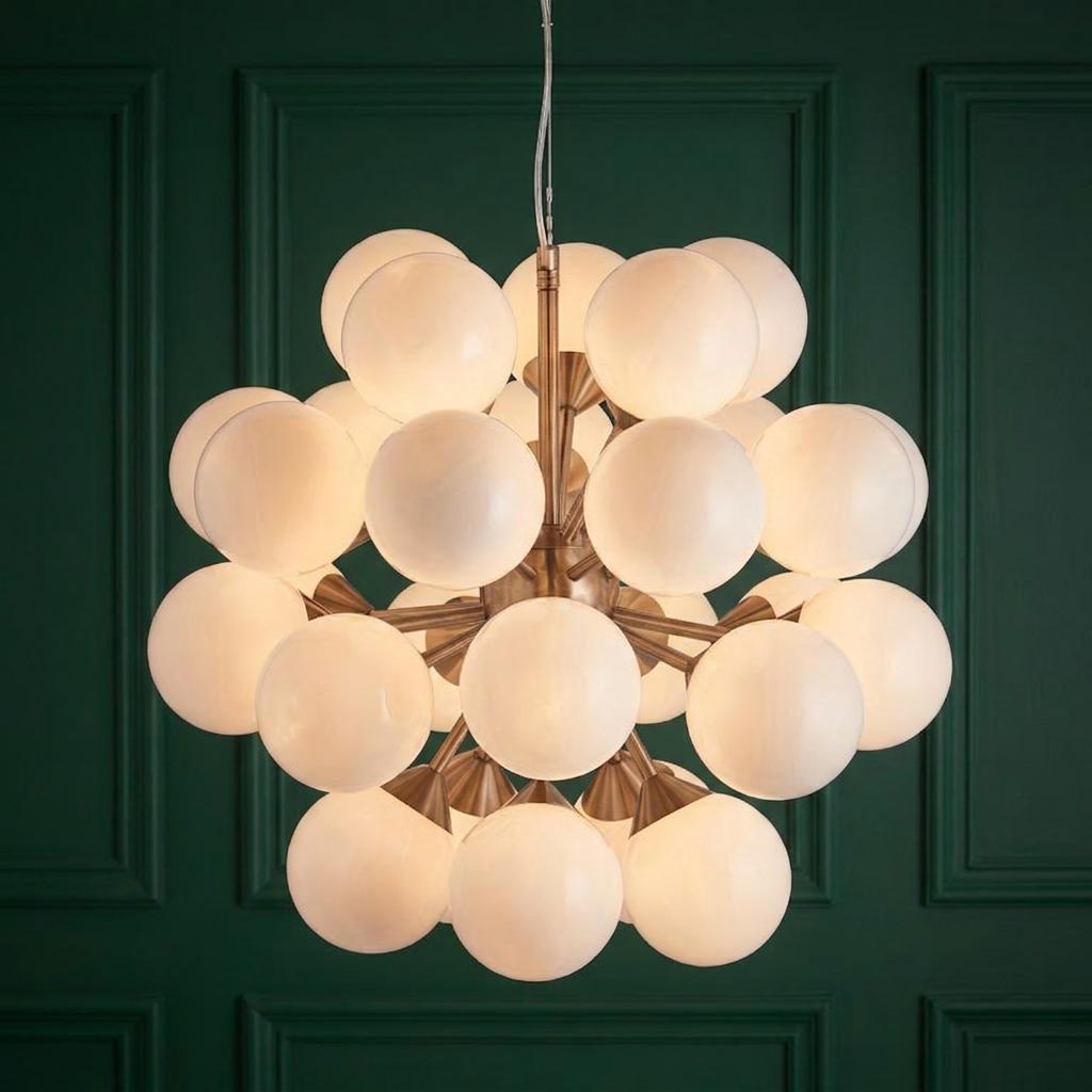 Endon Oscar 28 Light Nickel Finish Ceiling Pendant with white frosted globes against a dark green paneled wall.