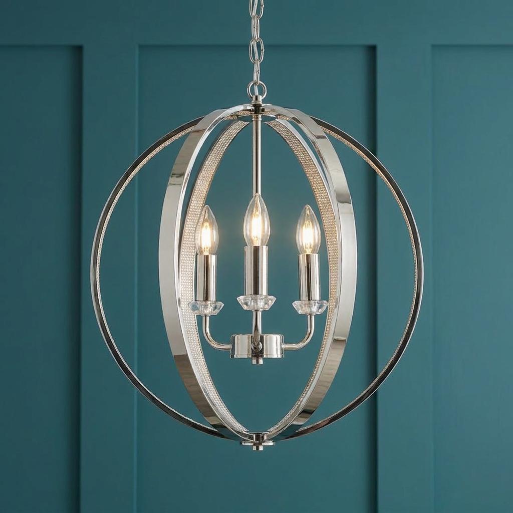 A polished nickel three-light orb pendant with crystal accents against a teal paneled wall.