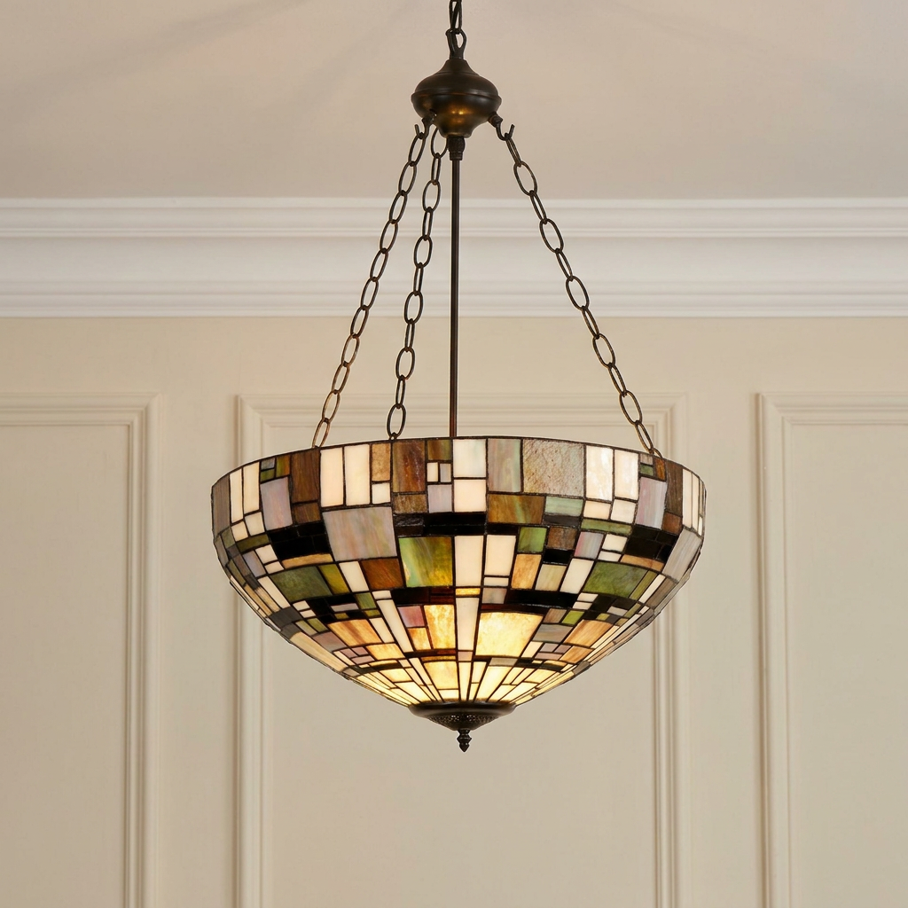 Inverted Tiffany ceiling light with a geometric stained glass shade suspended by bronze chains in a paneled room.