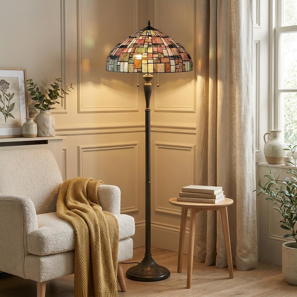 A Falling Water Tiffany floor lamp with a stained glass shade illuminates a cozy living room corner.