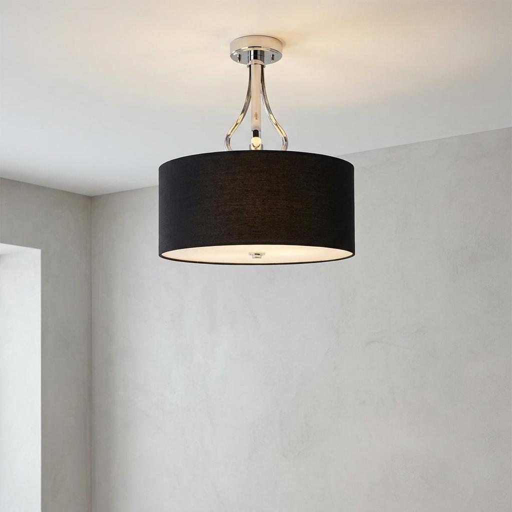 Modern semi-flush ceiling light with a black fabric drum shade and polished chrome metalwork against a grey wall.