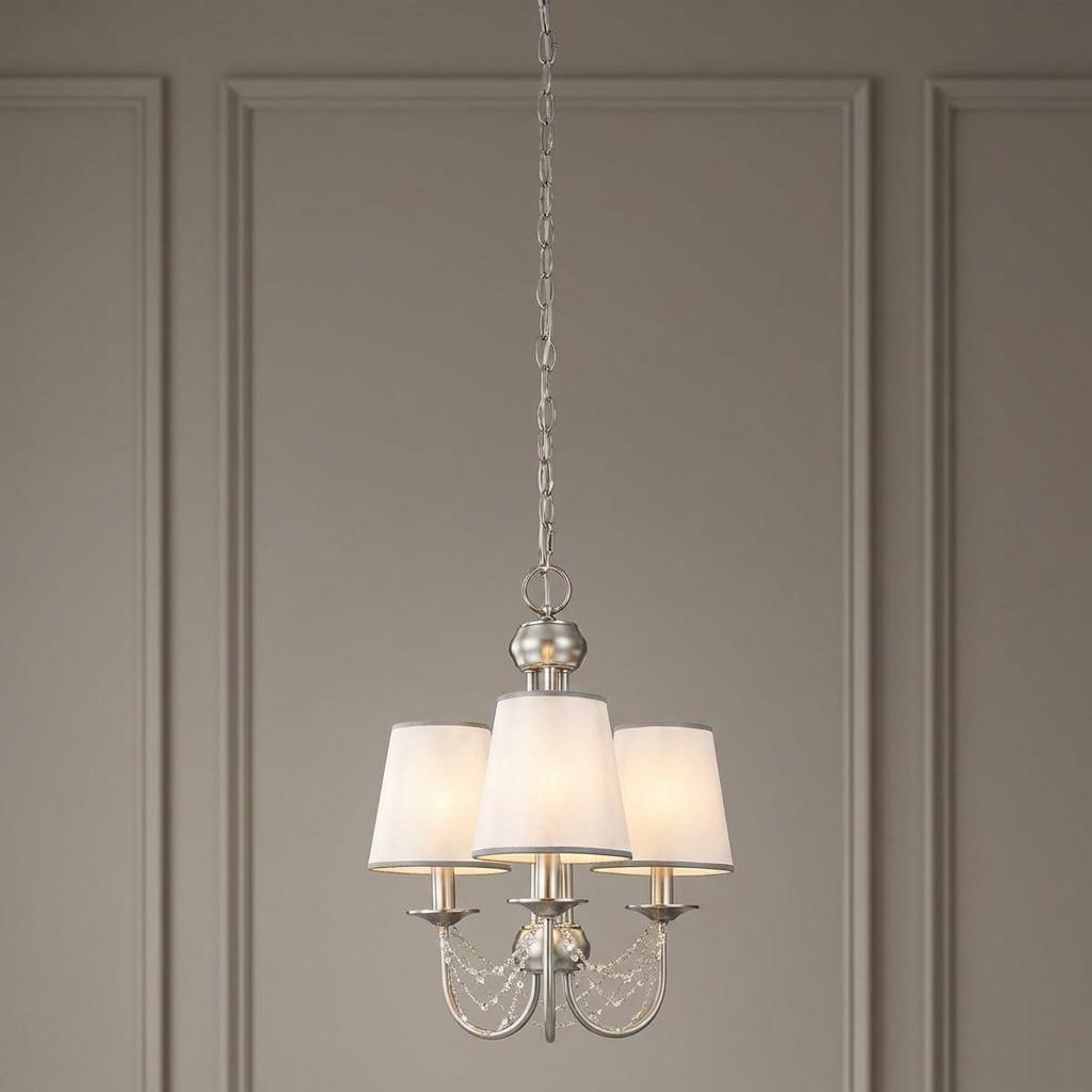 Feiss Aveline three-light brushed steel chandelier with white shades and crystal accents against a paneled wall.