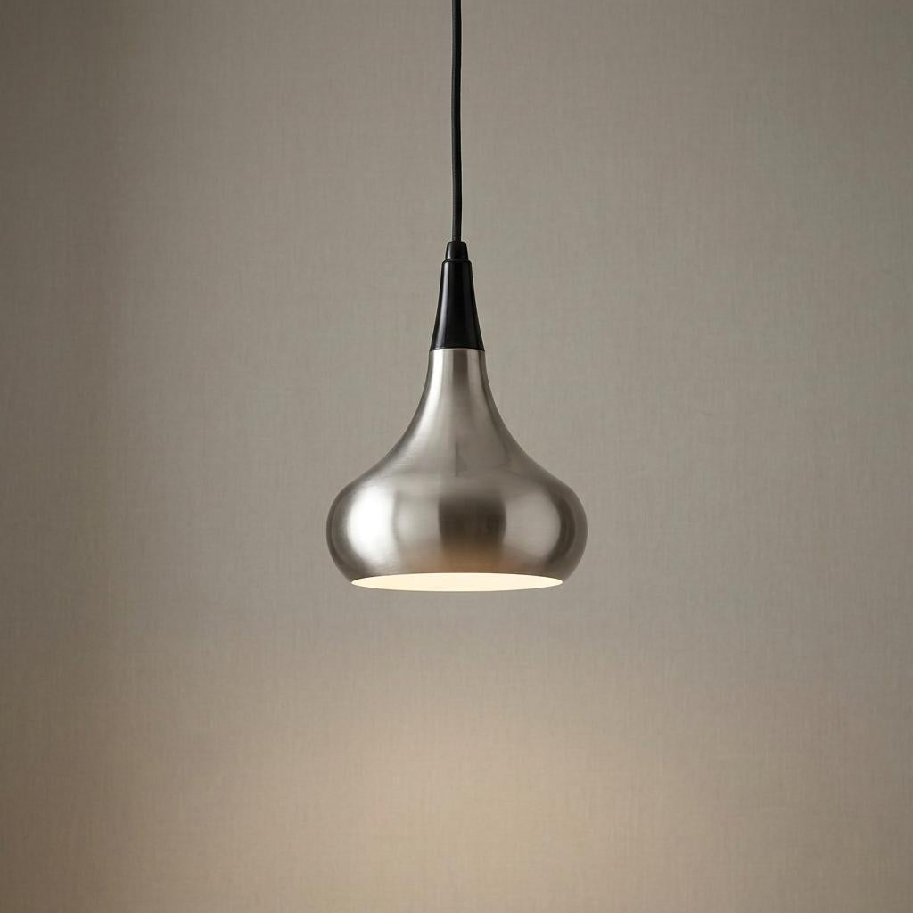 Illuminated brushed steel teardrop pendant light with a black cord against a neutral background.