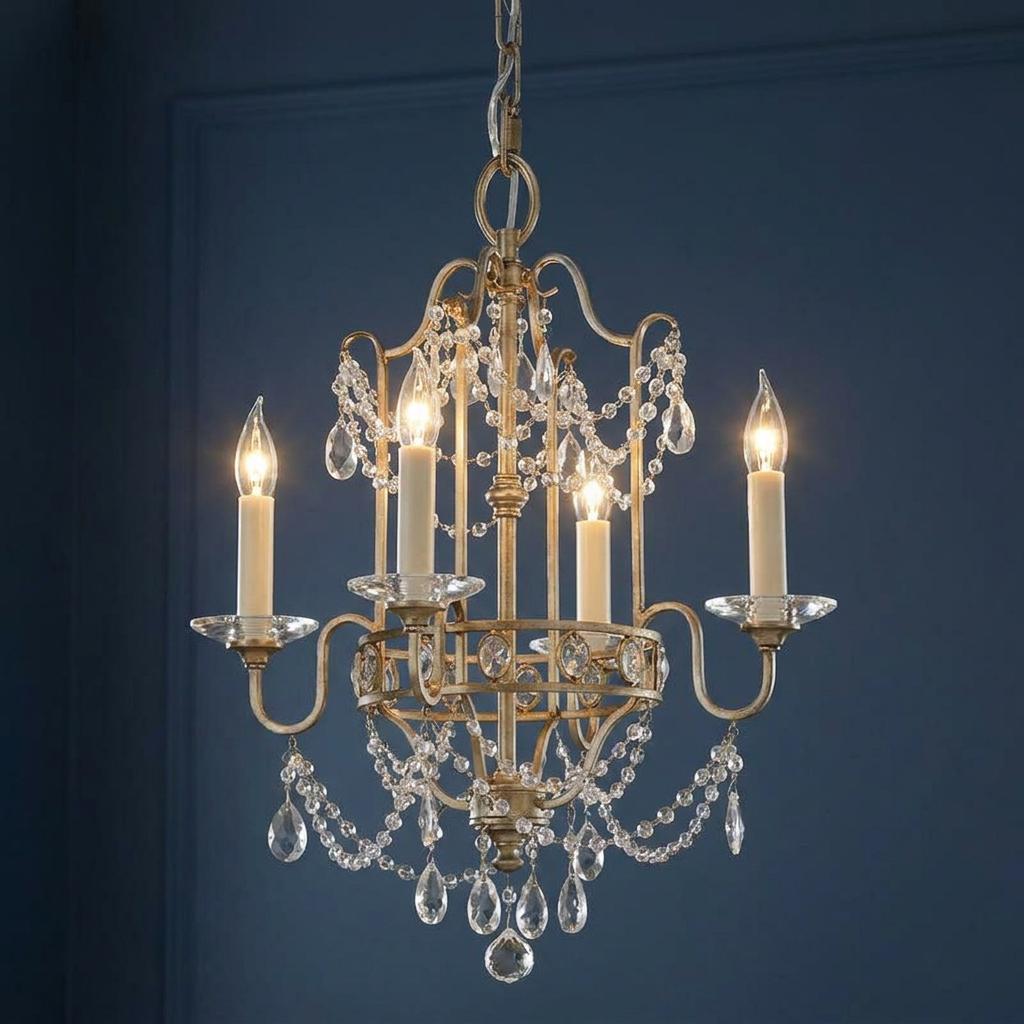 Gilded silver 4-light chandelier with crystal bead swags and glowing candle bulbs against a dark blue background.