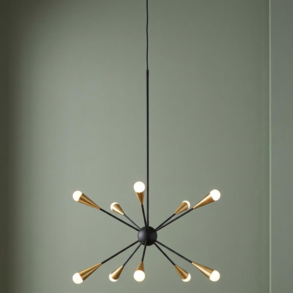 Feiss Jax 10-light sputnik chandelier in midnight black and gold hanging against a pale green wall.