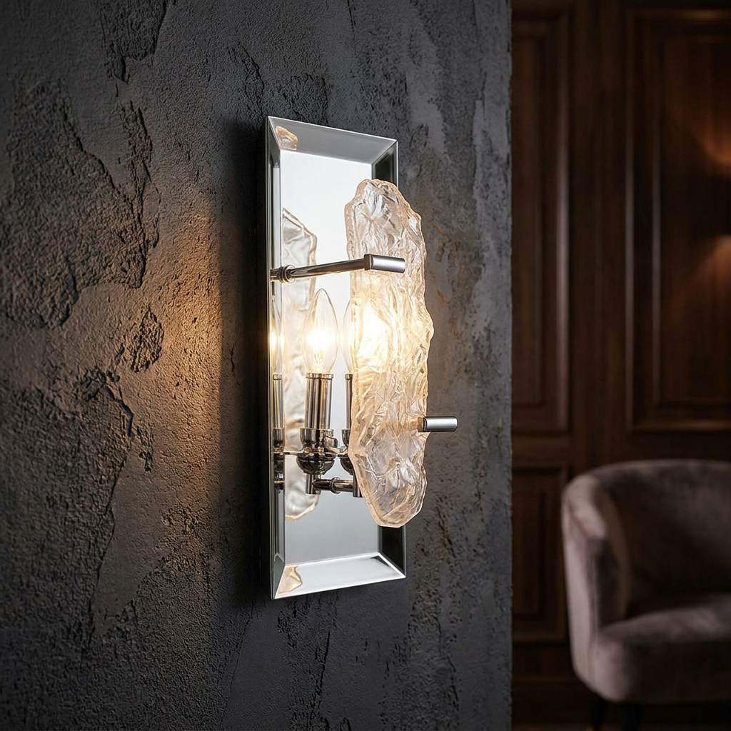 Chrome wall light with a mirrored backplate and textured glass shard, mounted on a dark textured wall.