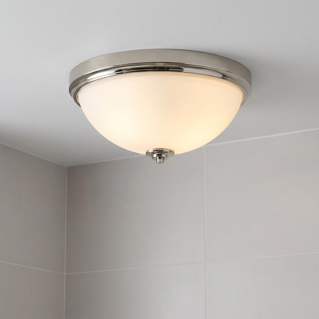 Polished nickel flush mount ceiling light with an opal glass shade installed in a bathroom setting.