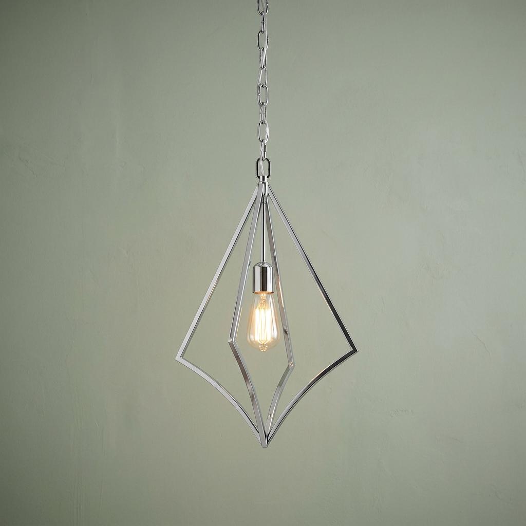 Modern polished chrome diamond-shaped pendant light with a visible filament bulb against a soft green wall.