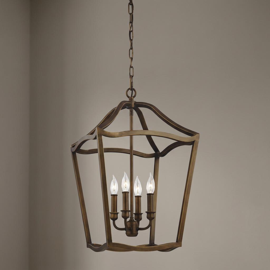 Painted aged brass 4-light pendant featuring an open-frame lantern design with a central candle-style cluster.