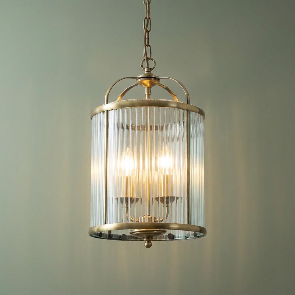 Fern double antique brass hallway ceiling light with fluted glass and two glowing bulbs against a sage wall.