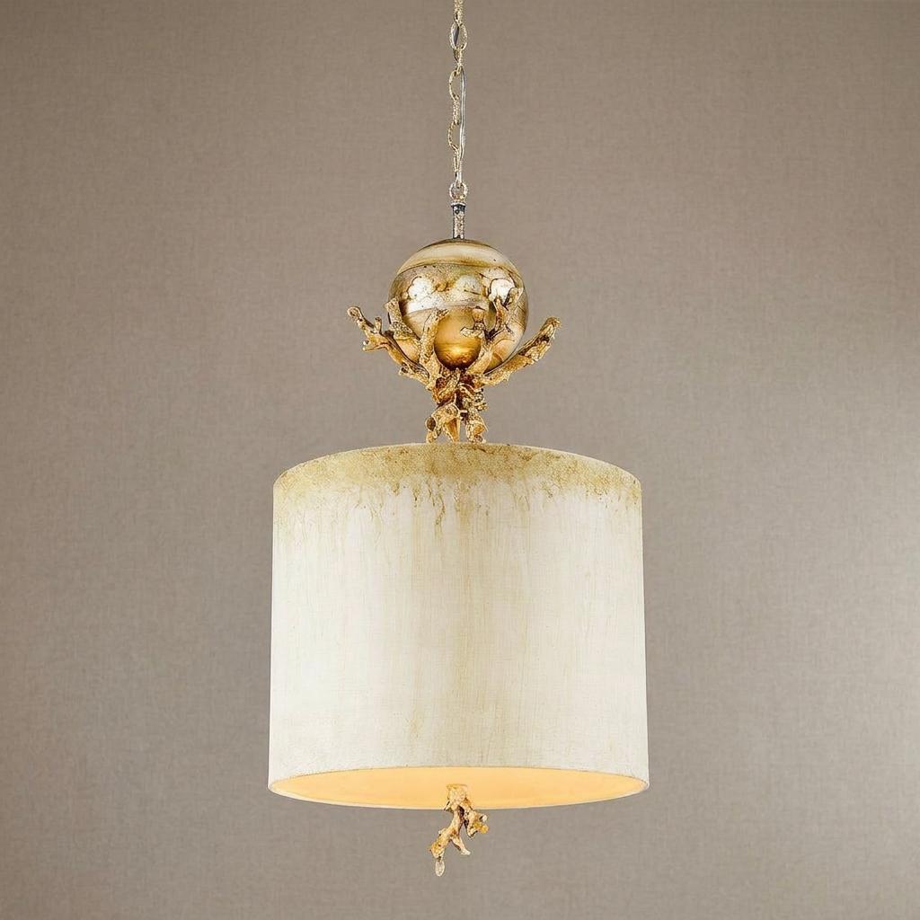 Elegant pendant light with cream drum shade, gold coral accents, and a silver orb against a neutral background.