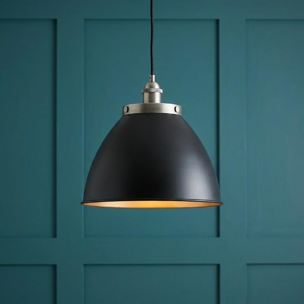 Matte black industrial dome pendant light with a warm interior, hanging against a teal paneled wall.