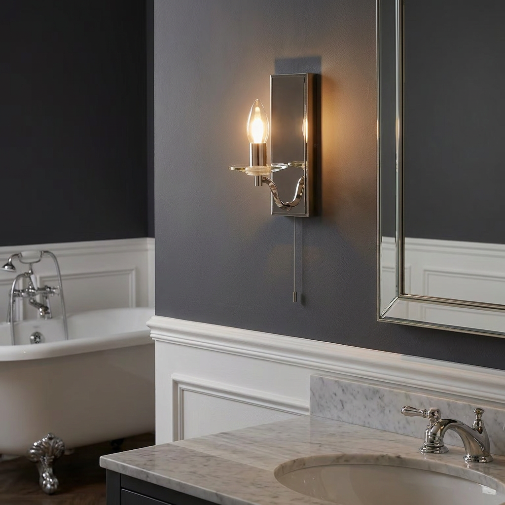 Nickel Art Deco wall light with a pull switch mounted on a dark grey bathroom wall next to a mirror.