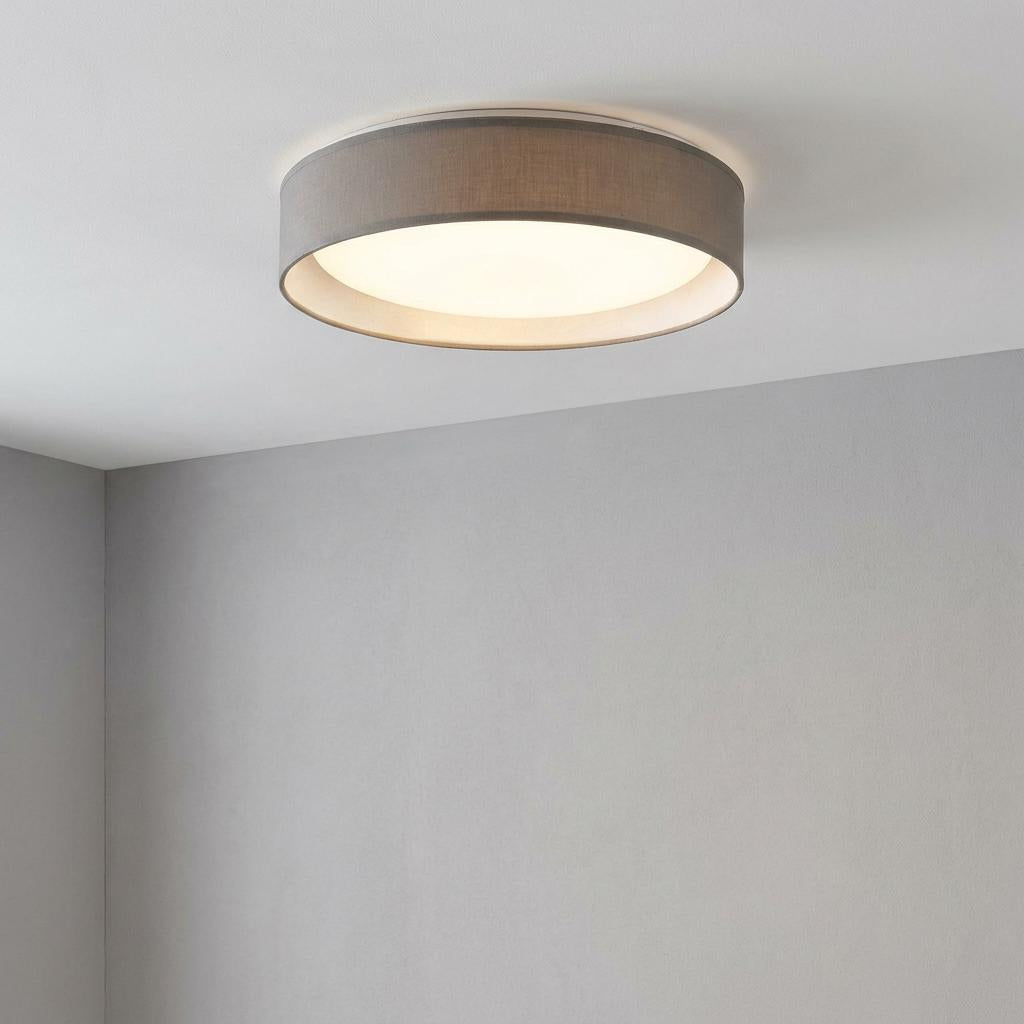 Gianna LED flush ceiling light with a grey fabric shade and frosted diffuser, illuminated on a white ceiling.