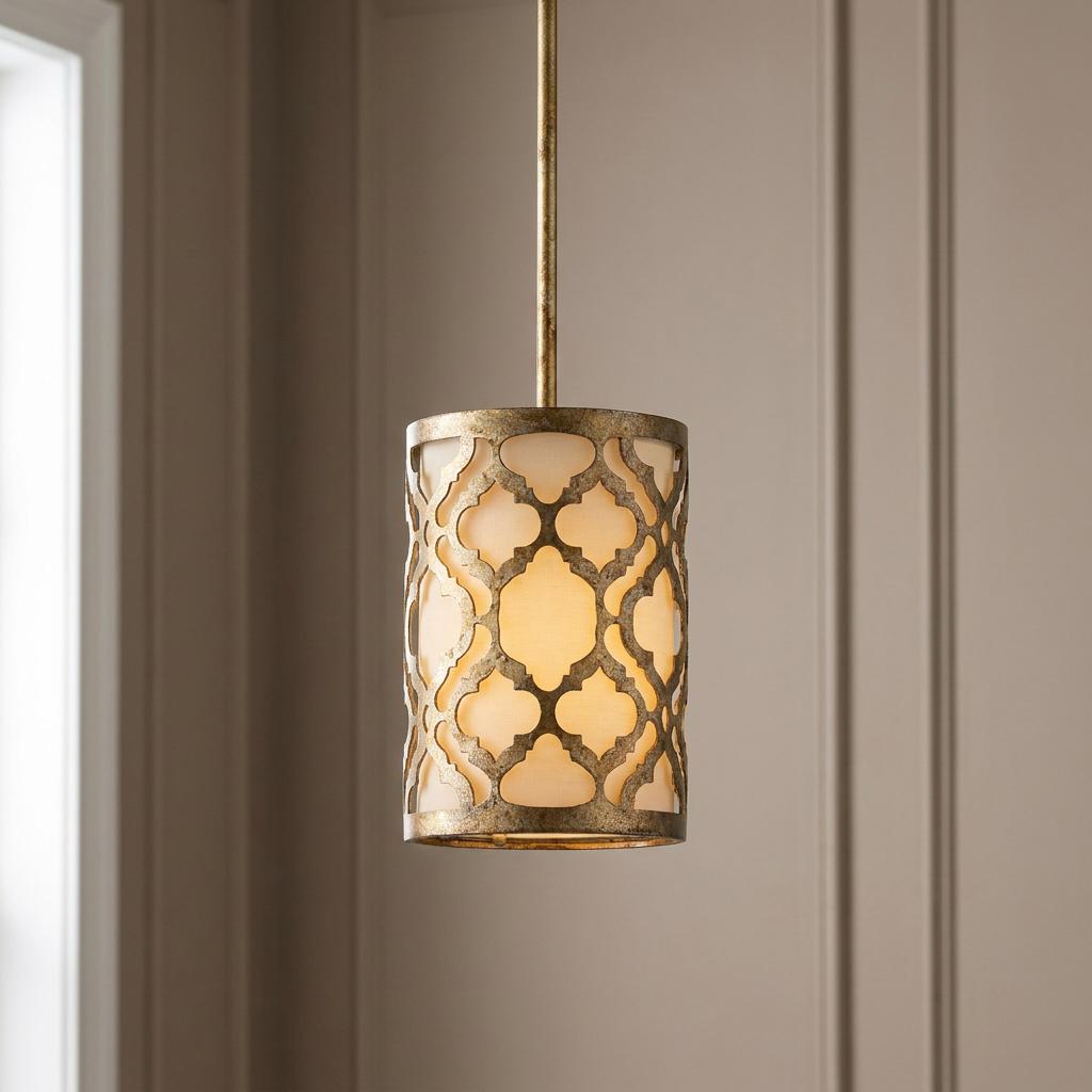 A gold mini pendant light featuring a cylindrical shade with a decorative lattice pattern and a warm inner glow.