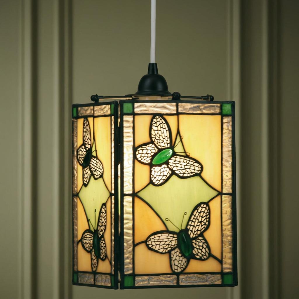 Square Tiffany-style pendant lamp shade featuring green and cream butterfly mosaic panels against a muted wall.
