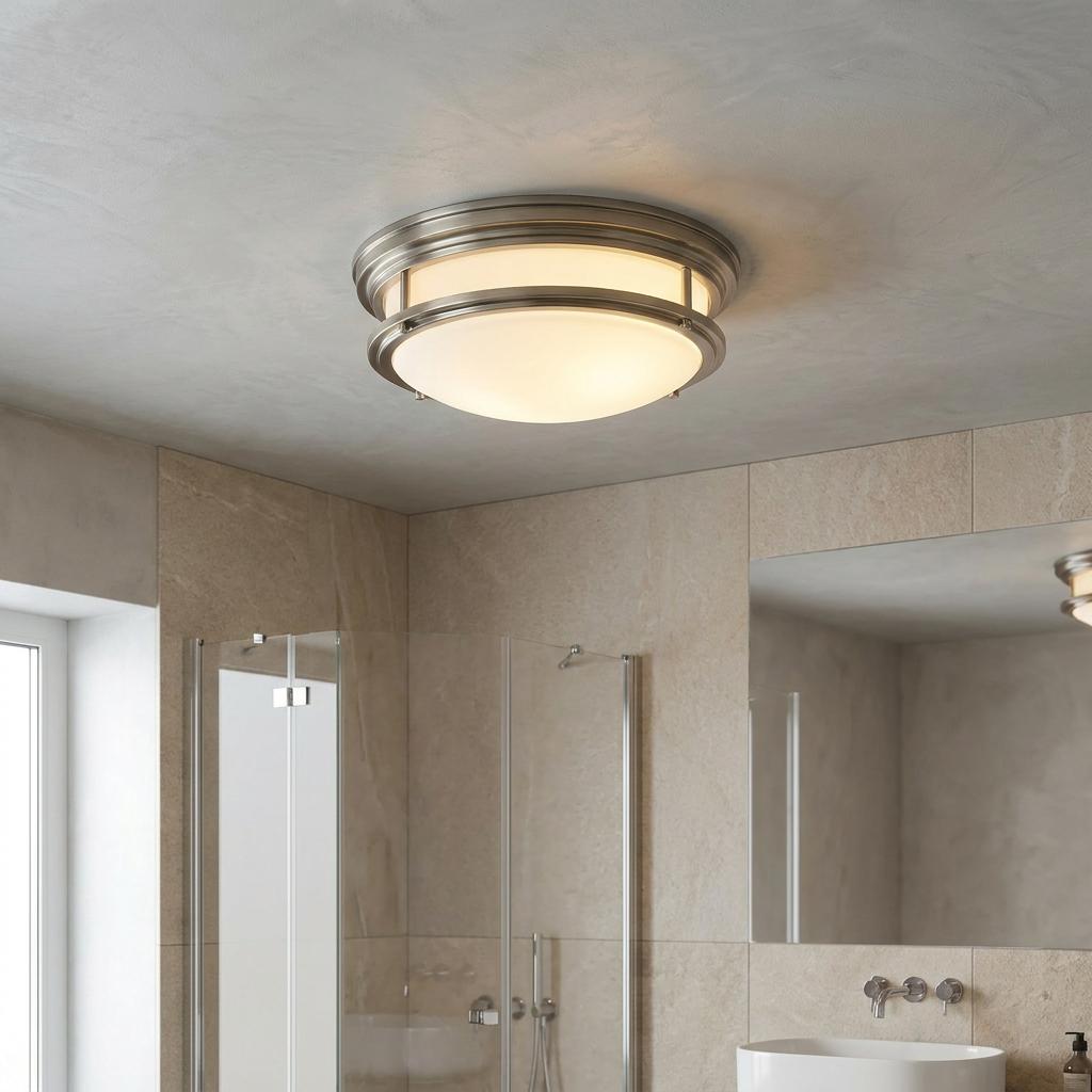 Hadrian antique nickel flush ceiling light with opal glass dome illuminated in a modern beige-tiled bathroom.