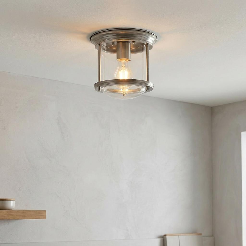 Antique nickel lantern-style flush ceiling light with clear glass shade illuminated in a modern interior.