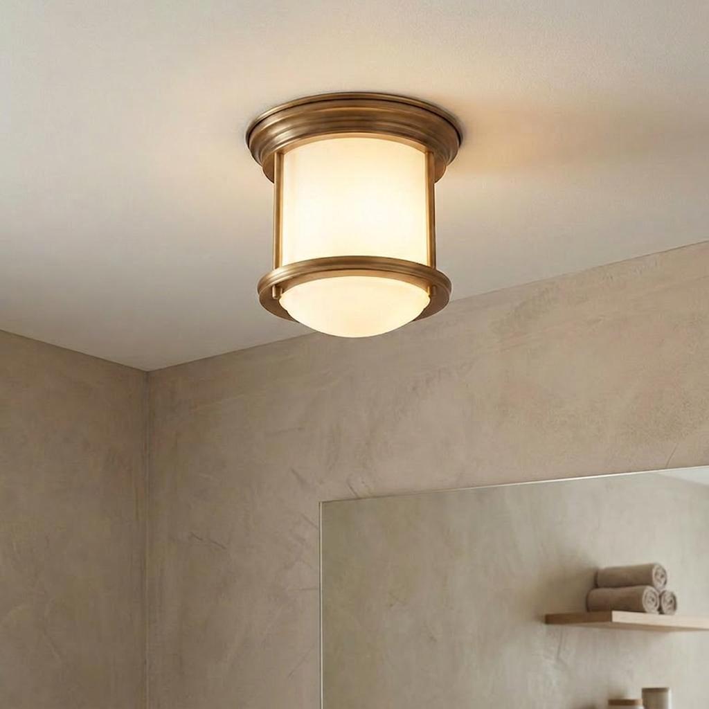 Flush bathroom ceiling light with opal glass and brushed bronze finish, mounted on a neutral ceiling.