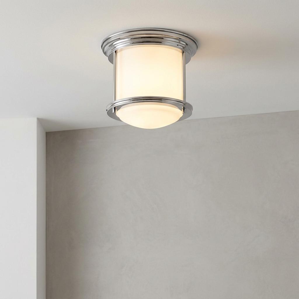 A Hadrian flush bathroom ceiling light with opal glass and chrome trim, glowing against a neutral wall.