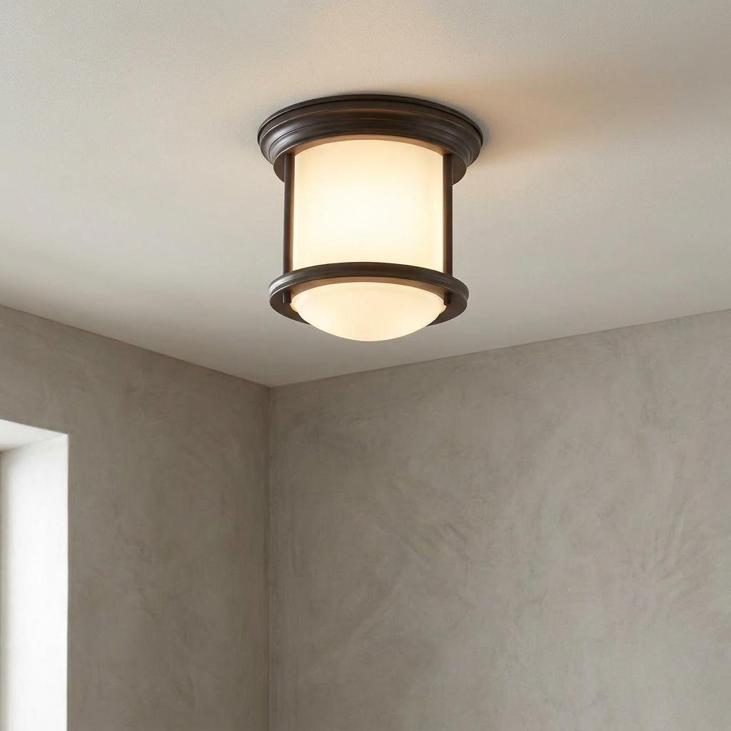 Hadrian flush bathroom ceiling light with oil rubbed bronze finish and illuminated opal glass on a white ceiling.
